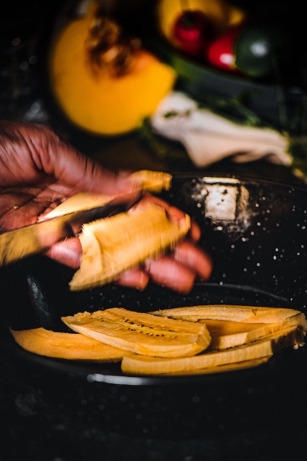 Datties Soul Food Academy caterer chopping plantain. 